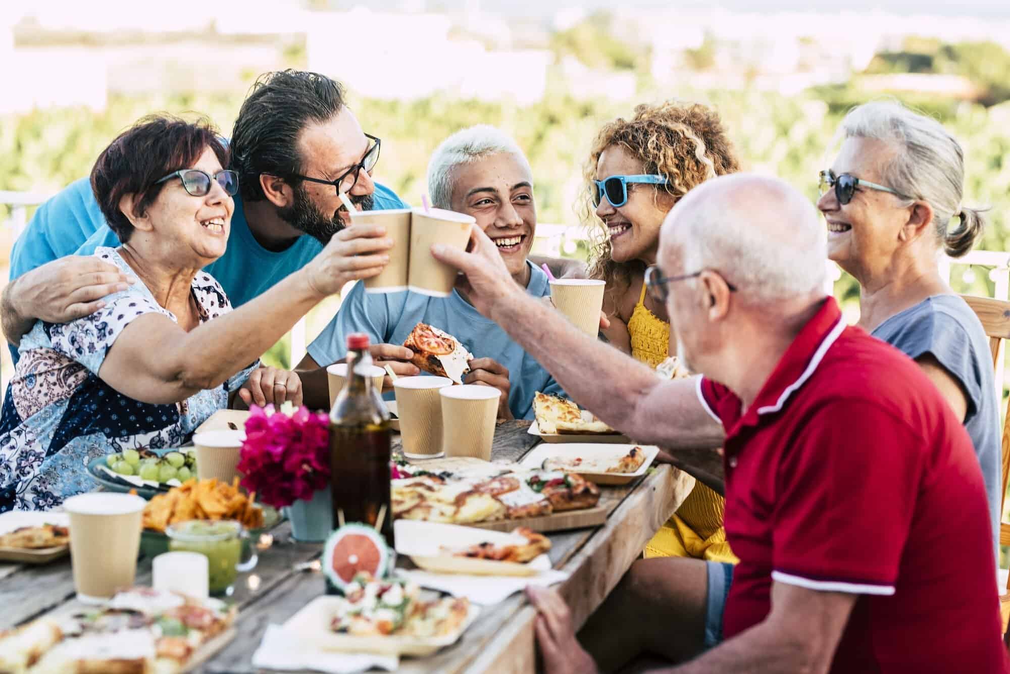 Group of different ages people celebrate and eat together