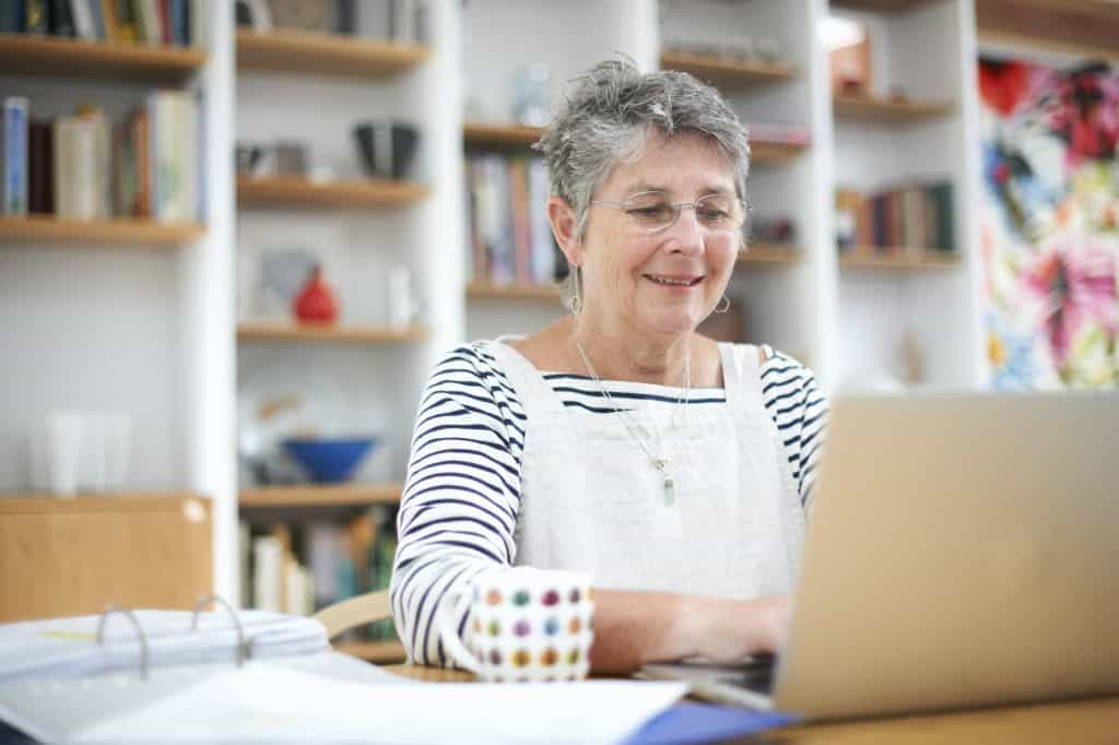 Senior woman at home, using laptop